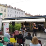 mężczyzna przemawia przez mikrofon w przestrzeni placu publiczneg