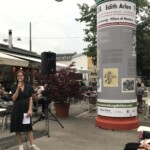 kobieta przemawia przez mikrofon w przestrzeni placu publicznego